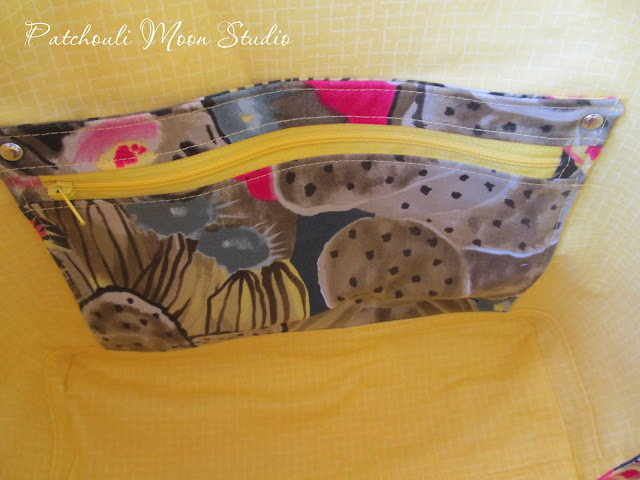 Lining of tote is bright yellow fabric with a zipper pocket in cactus print and a slip pocket behind the zipper pocket