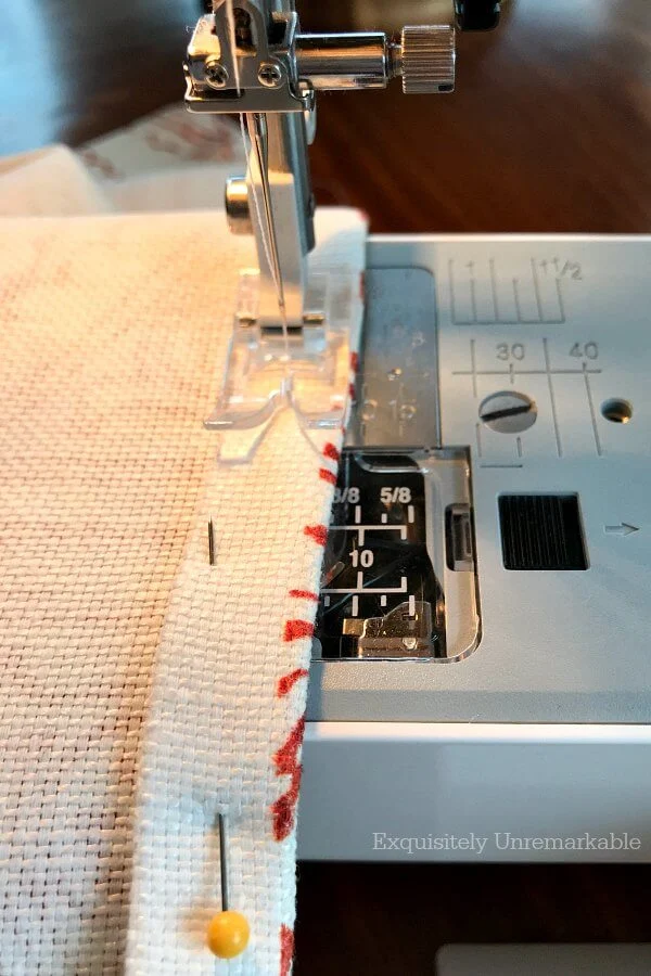 Sewing a red and white sink skirt on a machine