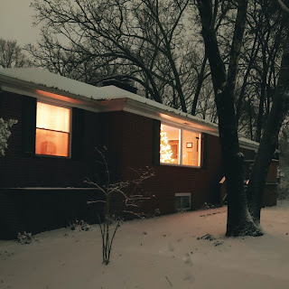 House with Christmas tree in the window in southern snow