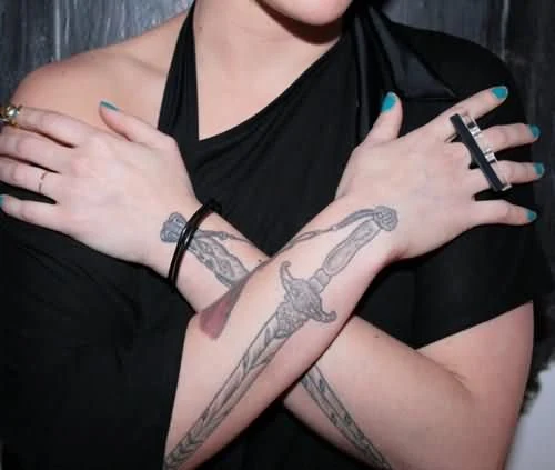 vemos a una mujer joven con tatuaje de cuchillo o tatuaje de daga