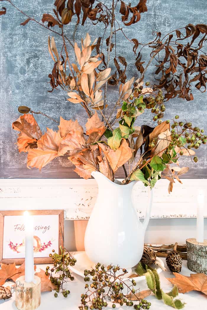 fall vignette with real dried branches and leave in ironstone pitcher, seed pods, berries, log branch candles and fall printable