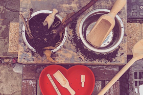 mini mud kitchen bowls with mud and wooden spoon