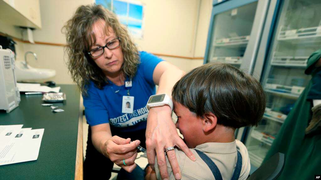 La enfermera registrada Starr Roden, coordinadora de acercamiento a la comunidad en el departamento de salud de Knox County, pone una vacuna a Jonathan Detweiler, un niño de 6 años en Mont Vernon, Ohio. Foto del 17 de mayo de 2019 / AP