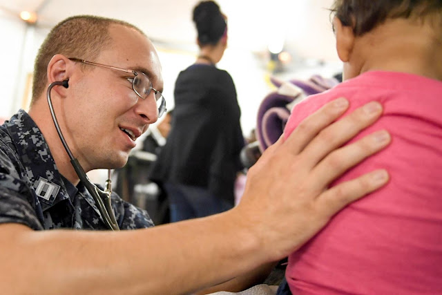 A man with a stethoscope comforts a patient.