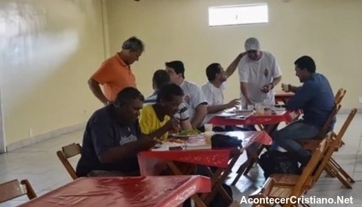 Indigentes comiendo en comedor de iglesia