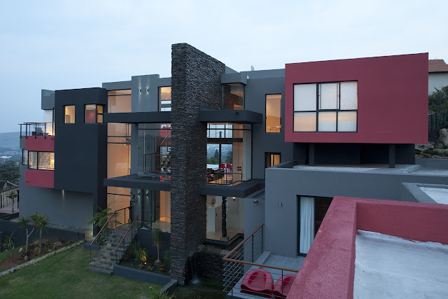 Picture of modern Lam House with grey and red facade as seen from the roof of the garage