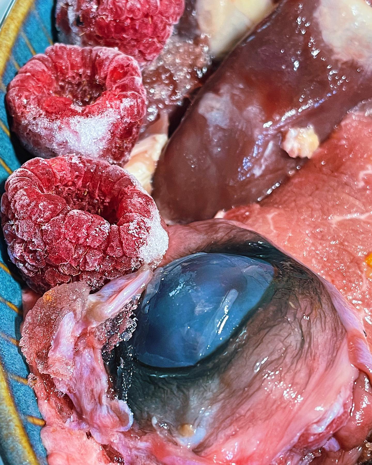 closeup photo of raspberries and beef eyeball