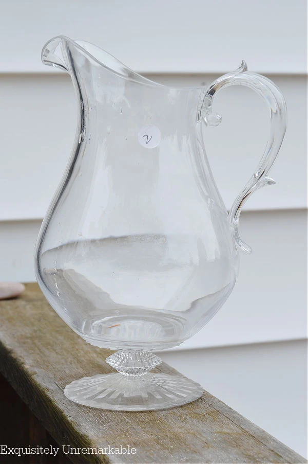 Clear Plastic Pitcher on a deck railing