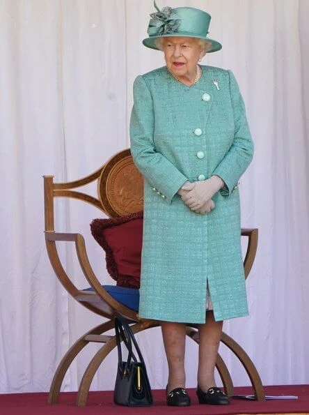 Queen is wearing a Stewart Parvin outfit, plus a floral silk dress with pleated hem detail, in shades of jade grey and dusty pink