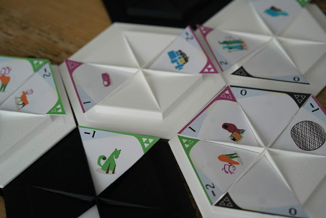 Plastic hexagons with insets where paper triangles with designs on them are placed.