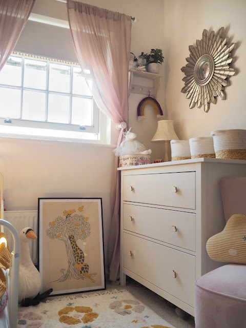 A pink and mustard yellow girls nursery bedroom, complete with cute accessories, colourful decor and homemade DIY touches. Including the IKEA Minnen bed, boho wall hanging, and IKEA hack dollhouse. Nursery inspiration and budget ideas.