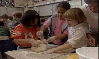 A group of children knead dough and bake bread. Sesame Street C is for Cooking