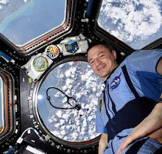 Drew Morgan aboard the ISS with a view of Earth in the background