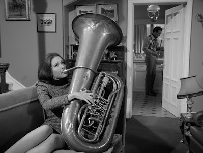 Diana Rigg as Emma Peel, playing the tuba