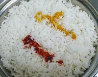 Pouring red chilli and turmeric powder dilution over rice for restaurant style veg biryani recipe