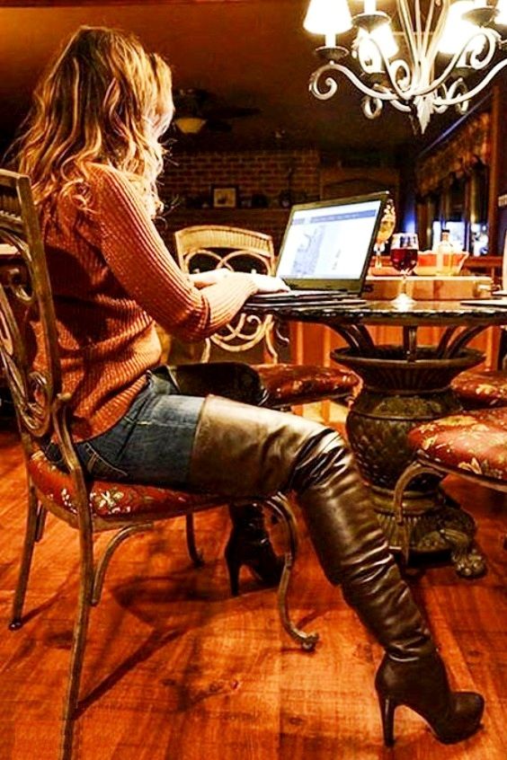 Woman wearing a brown sweater, jeans and brown over the knee boots