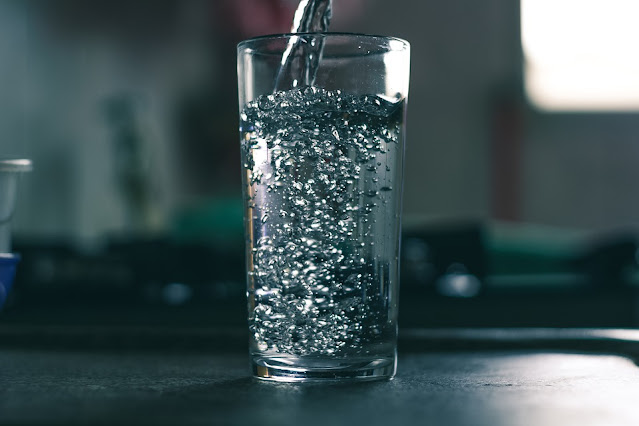 ماء يتم صبه داخل كوب زجاجي