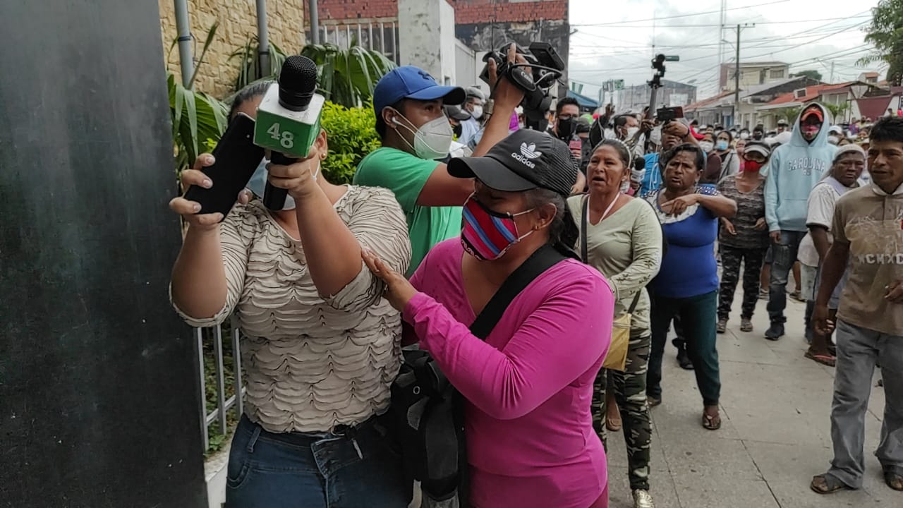 La periodista de Canal 48 de la ciudad de Montero, Vivian Pérez, trata de protegerse del ataque de padres de familia que reclamaban un bono escolar en especie / DIARIO ZONA NORTE