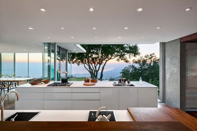 Kitchen in Home with White Counter and Long Island near Wide Glass Walls
