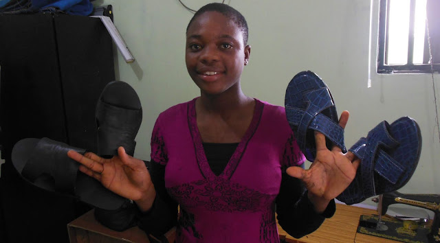 Girl holding Sandals she made