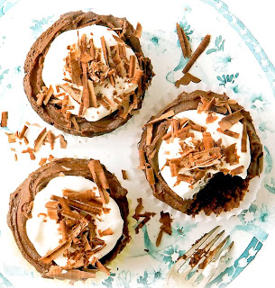 Black cherry and chocolate cupcakes with white frosting and chocolate shavings