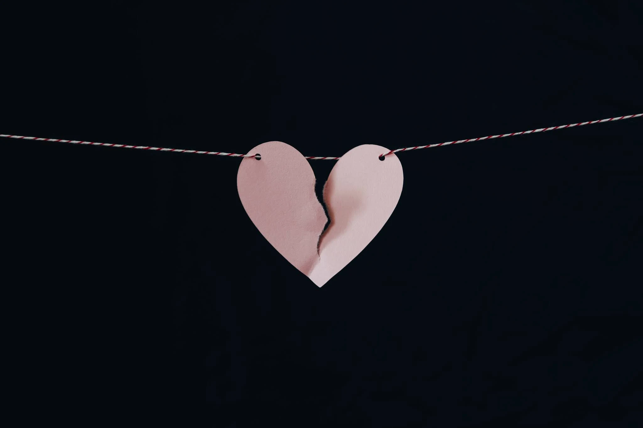 A paper heart on a string ripped in two