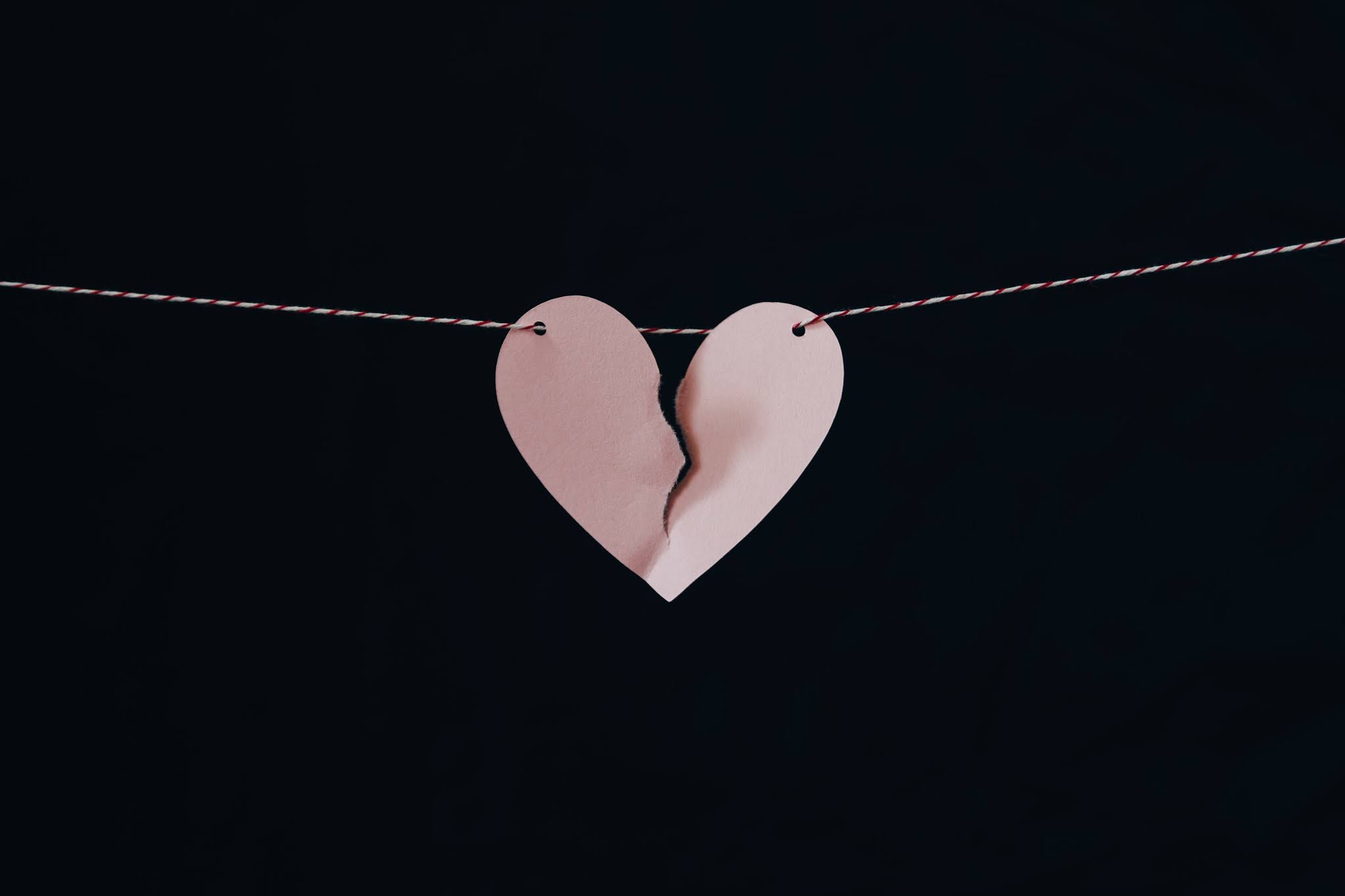 A paper heart on a string ripped in two