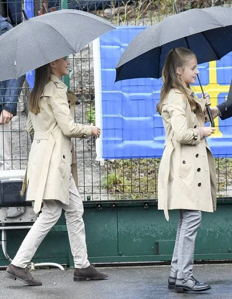 Crown Princess Leonor and Infanta Sofia wore Carolina Herrera trench coat, Mango Prince of Wales trousers. Queen Letizia