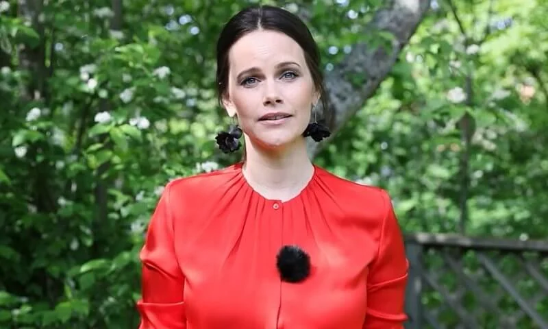 Princess Sofia wore a red silk satin, bell cuff long sleeve, gathered neck blouse, and black leaf earrings from Sanna Evers