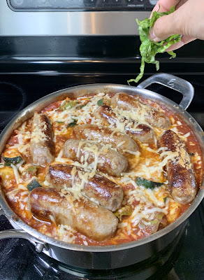 Basil  being added to a skillet of tortellini with sausage and zucchini. Basil  being added to a skillet of tortellini with sausage and zucchini.