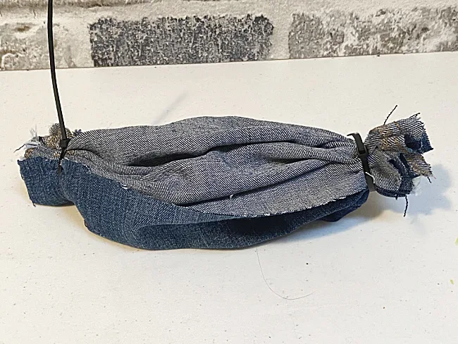 gathered ends of blue jean with zip ties