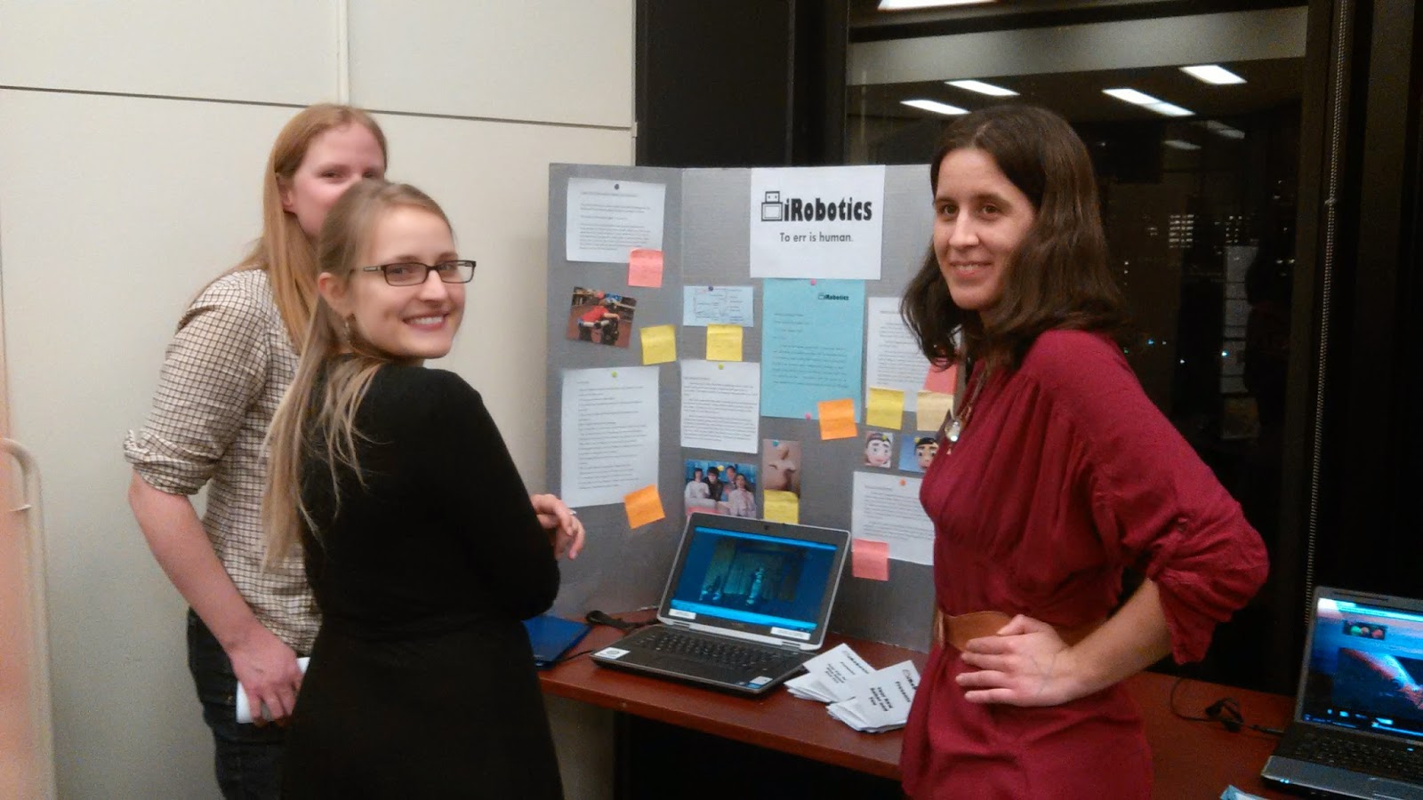 Photo of three women standing around a poster board.