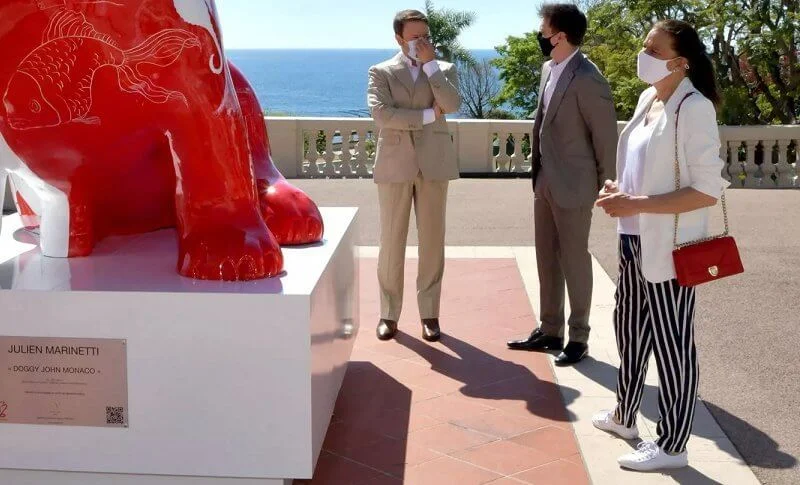 Princess Stephanie, Louis and Marie Ducruet at the inauguration of the sculpture of Doggy John. White jacket, striped pants, red bag