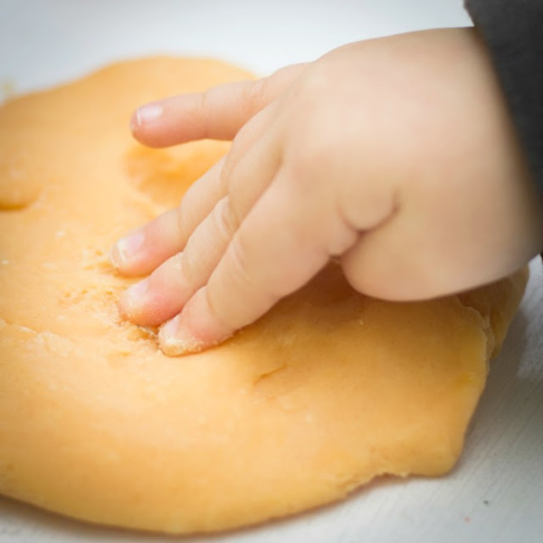Make play clay for kids using just two ingredients! #pumpkinplayclay #pumpkinplaydough #playdoughrecipe #pumpkinplaydoughrecipenocook #growingajeweledrose #activitiesforkids