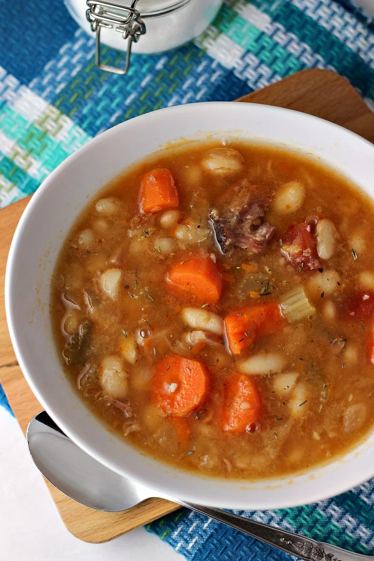 Overhead view of ham and bean soup in white bowl