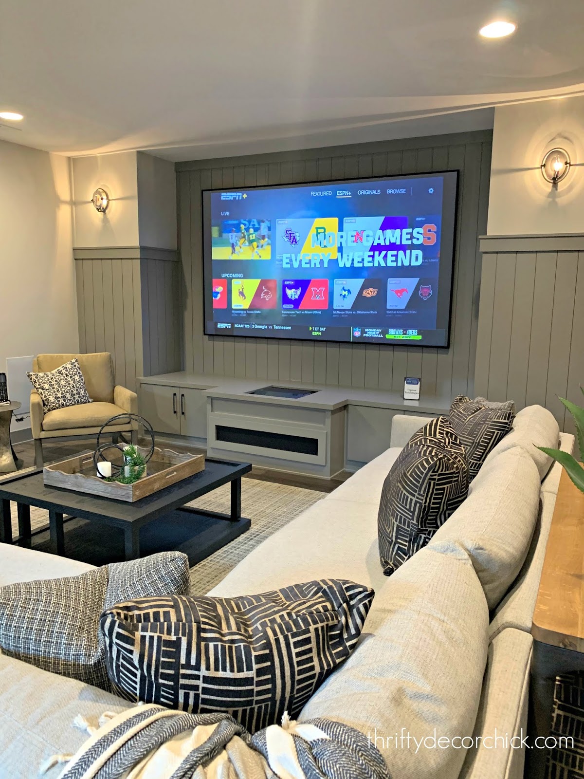 Family room in basement with gray vertical planked walls 