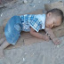 Kyrgyz boy sleeping on a piece of cardboard 