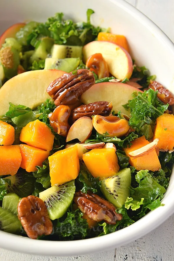 a bowl with chopped kale and fruits for easy kale salad 