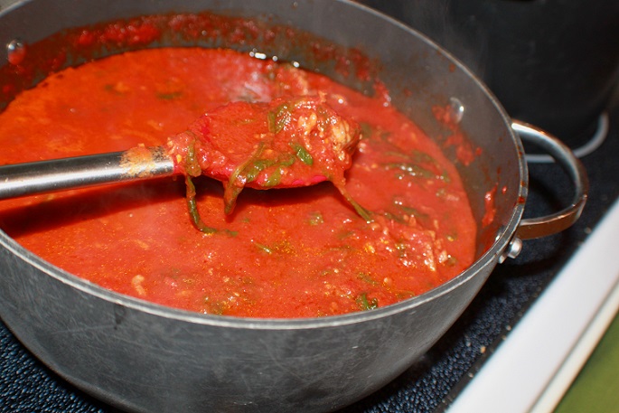 this is a pot of sauce with fresh basil marinara