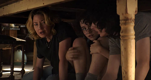 Callie (Carrie Coon), Phoebe and Trevor take cover underneath a table during a mysterious earthquake that strikes the small town of Summerville in GHOSTBUSTERS: AFTERLIFE.