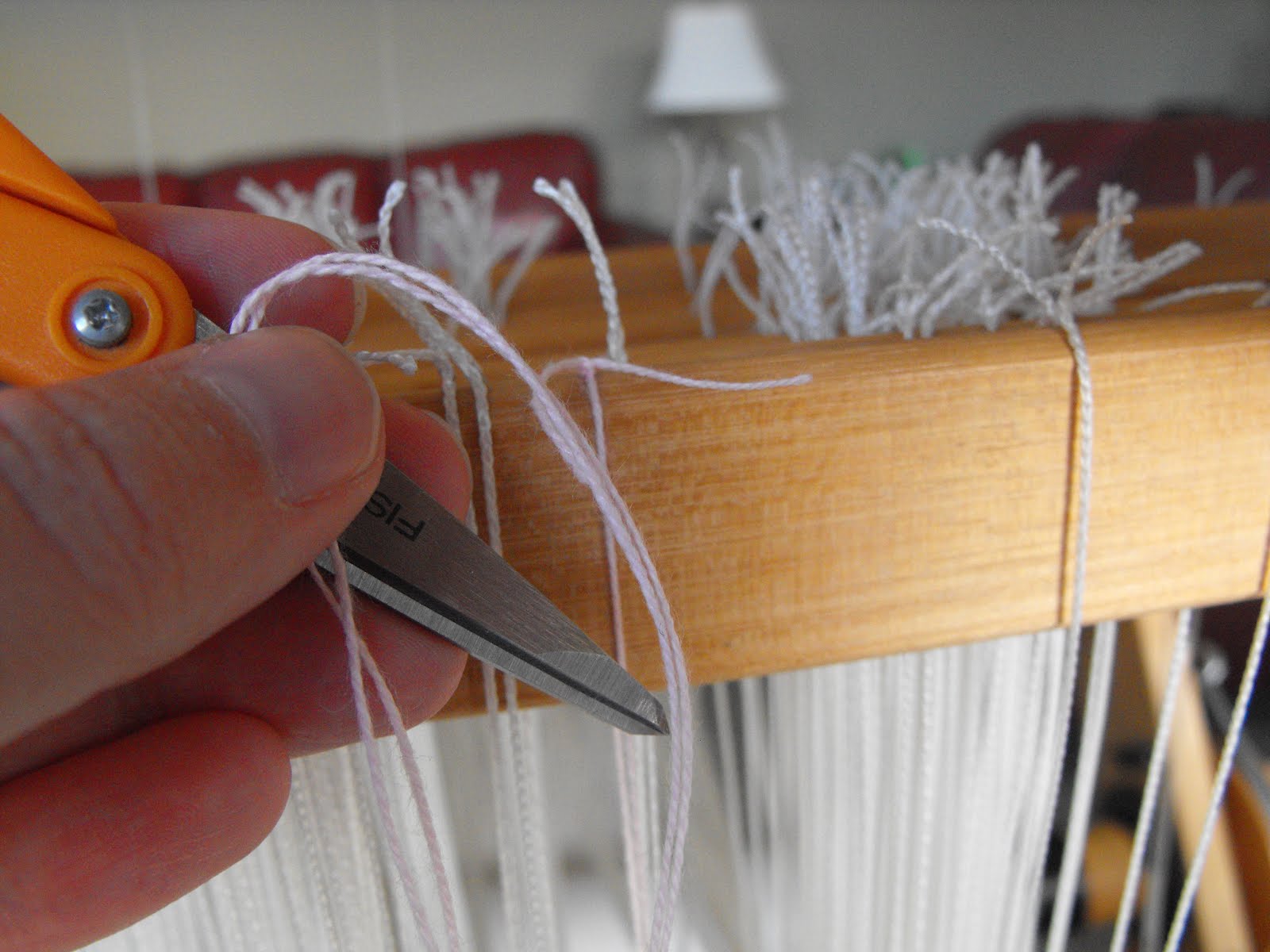 Dust Bunnies Under My Loom Tying a String Heddle