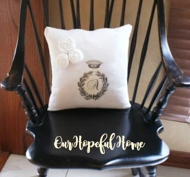 flour sack monogram pillow on black Windsor chair
