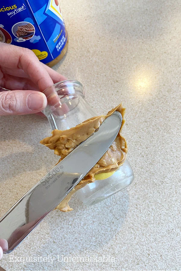 Spreading Peanut Butter On Glass with knife