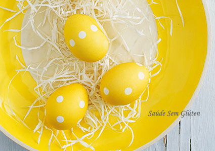 Ovos de páscoa brancos com sardas colocadas no feno amarelo tiro