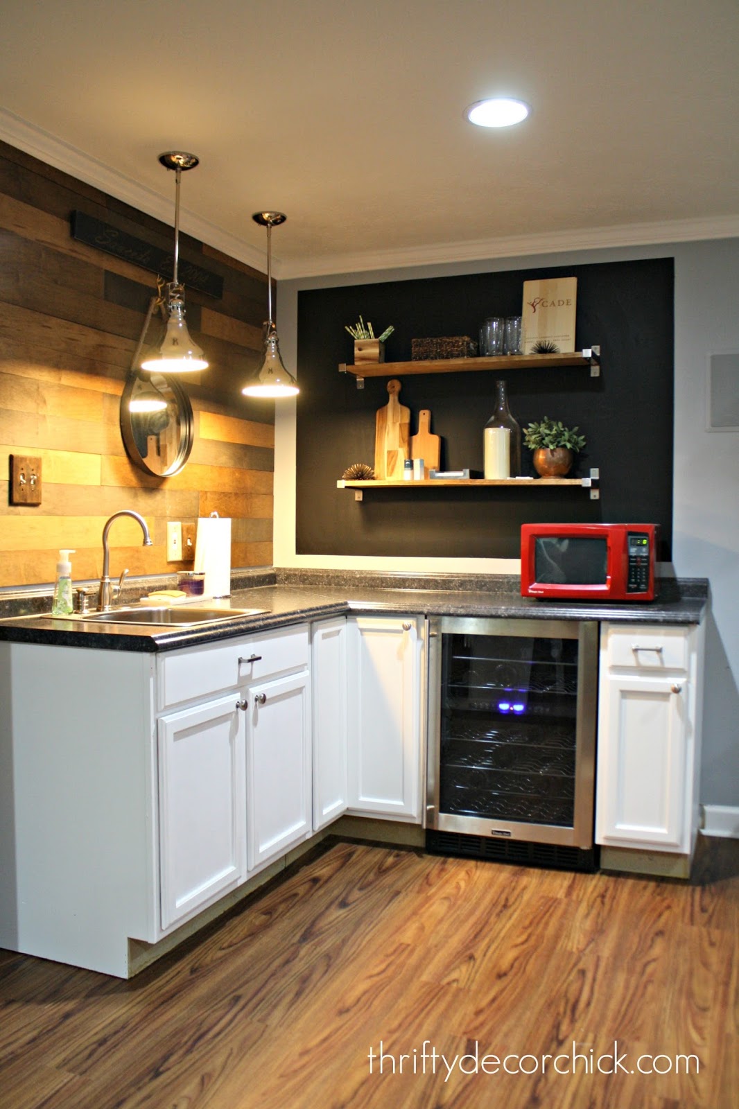 Basement kitchenette in corner with wood wall 