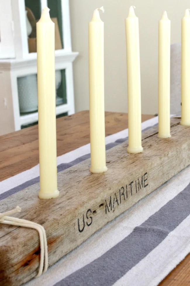 Row of candles with driftwood and stenciled words
