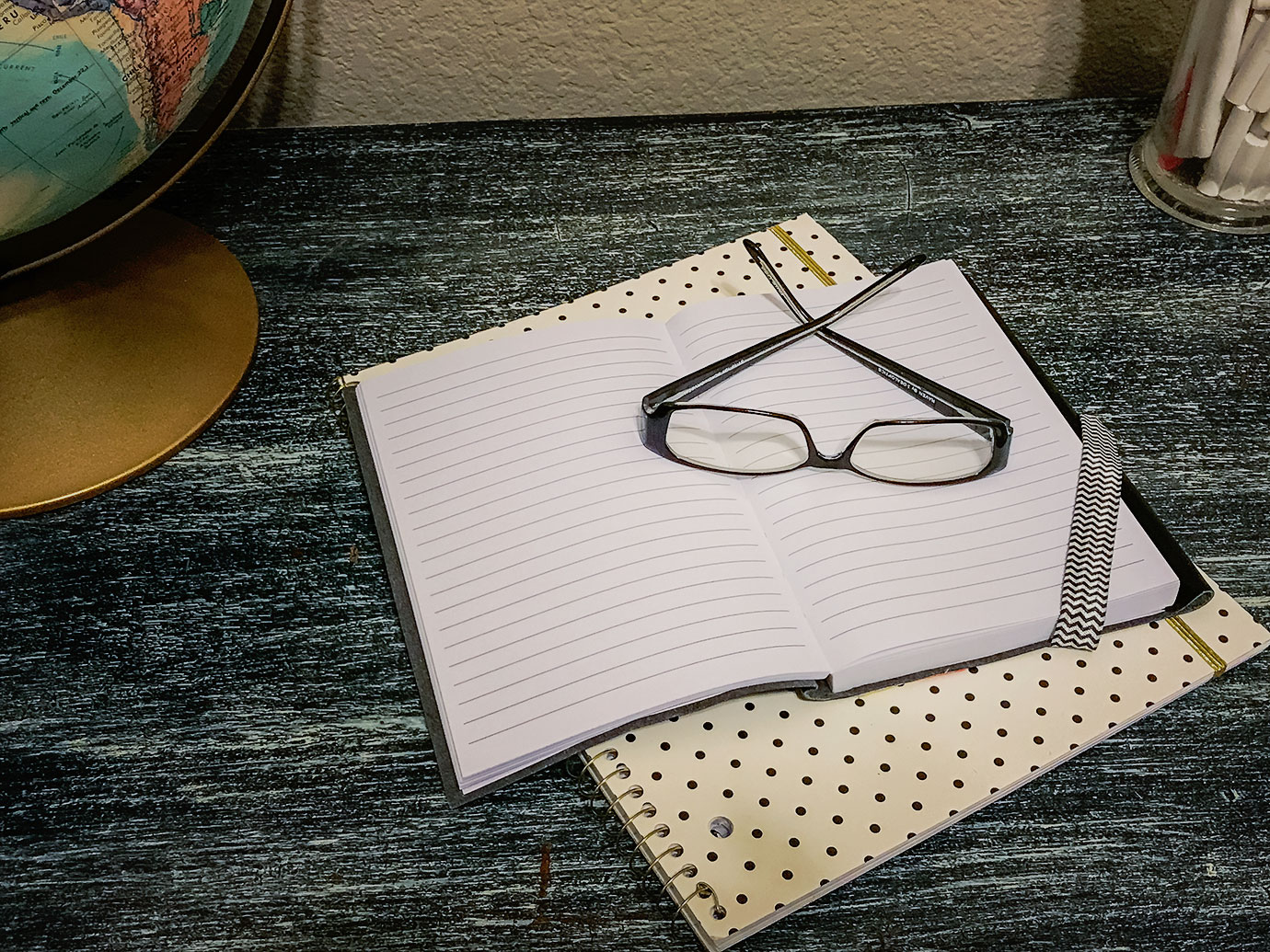 Polka Dot Note Book on a Black Desk with Glasses