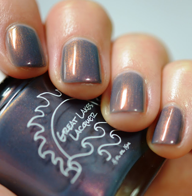 grey nail polish with copper shimmer swatched on white person's hands