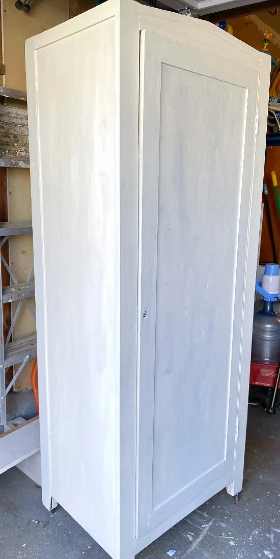 Large cupboard with first coat of white paint.