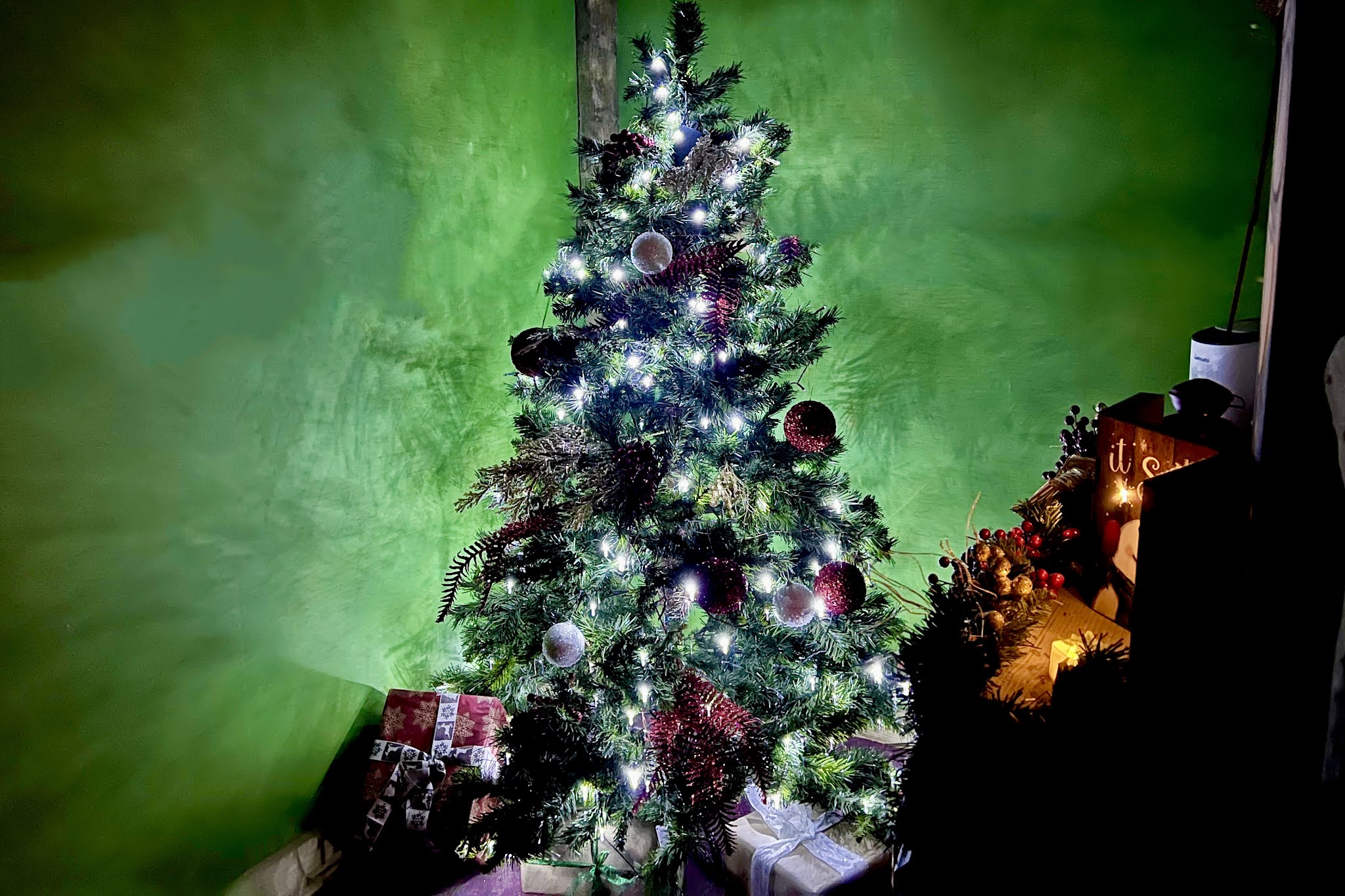 A christmas tree with presents underneath it and a green background